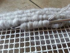 a pair of scissors sitting on top of a piece of white fabric next to some yarn