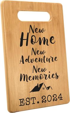 a wooden cutting board with the words new home and adventure in black ink on it