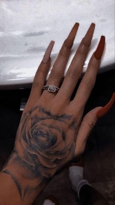 a woman's hand with a rose tattoo on it