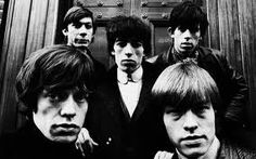 the beatles are posing for a photo in front of a door with their name written on it