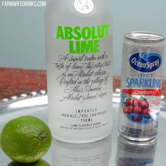 a bottle of vodka next to a lime and a can of sparkling water on a tray