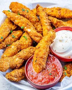 fried chicken sticks with ketchup and ranch dressing in a bowl on a table