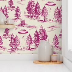 the wallpaper in this kitchen is pink and white with trees on it, as well as an alien flying saucer