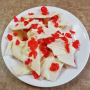 a white plate topped with pieces of cake covered in red confetti on top of a wooden table