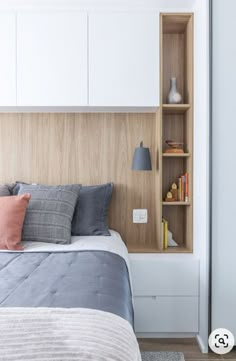 a bed sitting next to a book shelf in a bedroom