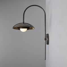 a lamp that is on the wall next to a light fixture in a room with gray walls