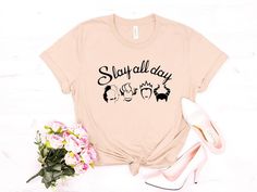 a t - shirt with the words stay all day on it next to shoes and flowers