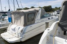 there are many boats docked at the dock in the water and one boat is covered with a tarp