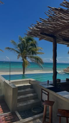 an outdoor bar with steps leading to the beach