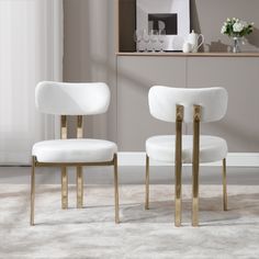 two white chairs sitting next to each other on top of a carpeted floor in front of a window