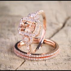 two wedding rings on top of each other sitting on a piece of wood with diamonds around them