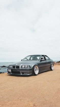 a car is parked on the beach by the water