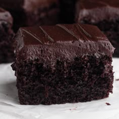 a piece of chocolate cake sitting on top of white paper