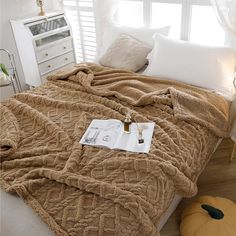 a bed covered in a brown blanket and pillows