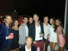 a group of people standing next to each other in front of a building at night