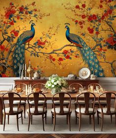 a dining room table with chairs and two peacocks painted on the wall behind it