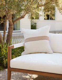 a white chair with a black and white pillow sitting on it's armrest