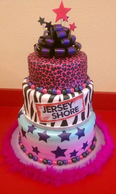 a three tiered cake decorated with zebra print and pink, purple, and black stars