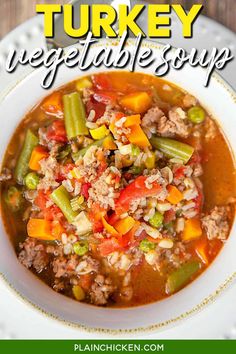 turkey vegetable soup in a white bowl with green beans and carrots