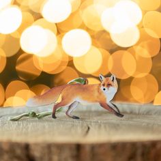 a figurine of a fox on a table with boke lights in the background