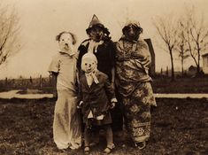 an old black and white photo of three people dressed up as clowns, one with a dog on his head