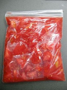 a plastic bag filled with tomatoes on top of a table