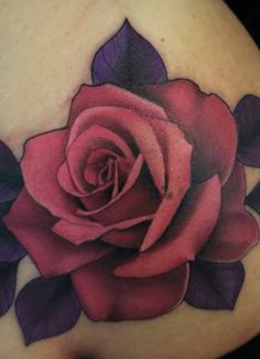 a rose tattoo on the back of a woman's shoulder