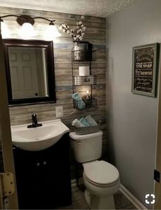 a bathroom with a toilet, sink and mirror