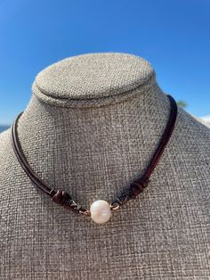 Classic yet Modern and Trendy Necklace. This could be worn by anyone who loves pearls and wants a classic look for a dressier attire or just to wear with a simple tee and jeans. I selected a dark cherry brown leather that is 2mm in size and doubled the strands. The strands of leather are triple barrel knotted as an accent to the beautiful creamy freshwater cultured pearl in the center. The pearl is 12mm in size. It is secured to the necklace with copper accents.  There is a magnetic clasp for easy on and off. I know you will love this with so many styles of clothing to business casual, coastal, boho, western wear and just a simple tee shirt and jeans.  This would also look amazing in the collar of your favorite dress shirt or denim jacket. This is a One of A Kind necklace. Elegant Brown Single Strand Pearl Necklace, Elegant Single Strand Brown Pearl Necklace, Corded Necklace, Dressy Attire, Cherry Brown, Casual Coastal, Coastal Boho, Trendy Necklace, Leather Corded Necklace