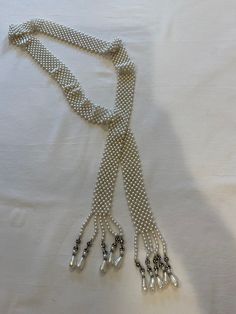 Beautiful vintage faux pearl intricately woven long lariat necklace dripping with rhinestone and pearl drops. Would be a perfect piece to add that special touch to complete the look. Measuring 58" in length. Silver Beaded Lariat Pearl Necklace, Lariat Pearl Necklace With Charm For Parties, Pearl Lariat Necklace For Party, Elegant Beaded Pearl Lariat Necklace, Silver Lariat Pearl Necklace For Party, Elegant Pearl Beaded Lariat Necklace, Elegant Beaded Fringe Jewelry, Elegant Beaded Pearl Necklace With Dangle, Elegant Adjustable Beaded Necklaces With Fringe