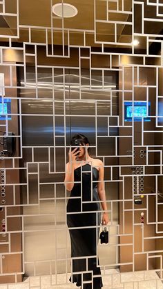 a woman standing in front of a mirror holding a cell phone