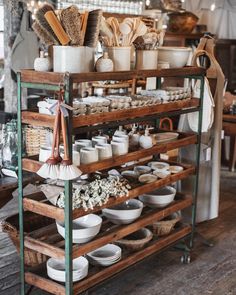 an old wooden shelf filled with dishes and other kitchen utensils on it's sides