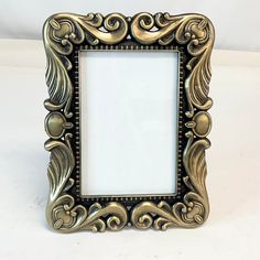 an ornate gold frame on a white surface with a blank space in the middle for text