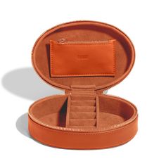 an orange leather jewelry box with its lid open to show the inside compartments and zippers