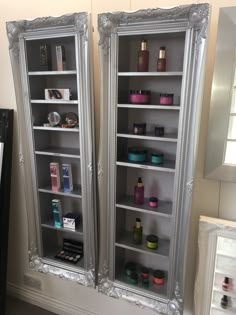 two large mirrors are next to each other in front of a shelf with cosmetics on it