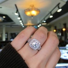 a close up of a person's hand holding a diamond ring