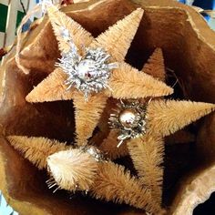 three star ornaments in a brown paper bag