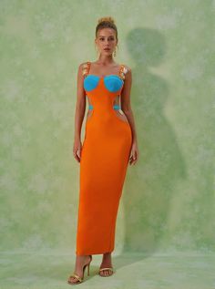 Margaux Embellished Cutout Maxi Dress in Orange Step into the spotlight with the Margaux Embellished Cutout Maxi Dress. This stunning dress combines elegance and allure through its unique design elements, making it perfect for special occasions or nights out on the town. Dress Details The Margaux dress is crafted from a luxurious bandage material featuring 95% polyester and 5% spandex for a comfortable fit. Its intricate cutout design and metal embellishments add an extra layer of sophistication Orange Bodycon Dress For Party, Orange Bodycon Party Dress, Fitted Orange Maxi Dress For Party, Orange Long Dress For Evening, Orange Maxi Party Dress, Orange Evening Maxi Dress, Orange Maxi Length Party Dress, Evening Bodycon Dress With Cutout, Evening Bodycon Dress With Cutout Details