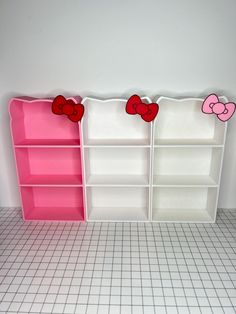 two bookshelves with pink and red hearts on them in a white tiled room