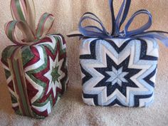 two wrapped presents sitting on top of a white blanket covered floor next to each other