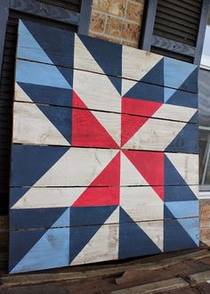 a wooden block with a red, white and blue quilt on it's side