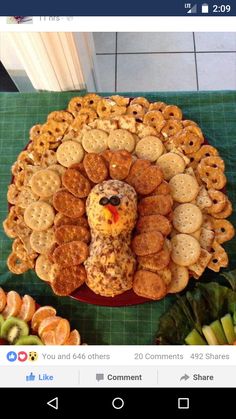 a turkey made out of crackers sitting on top of a table next to fruit