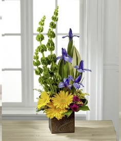 a vase filled with flowers on top of a wooden table