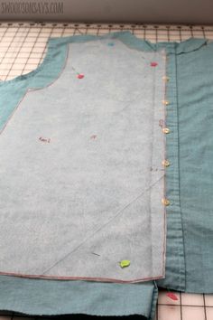 a piece of fabric sitting on top of a cutting board next to scissors and thread