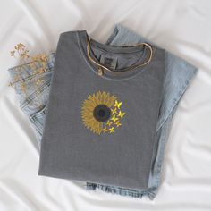 three pairs of jeans with embroidered sunflowers on the front and back, sitting next to each other