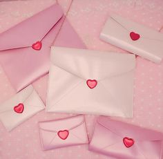 four envelopes with hearts on them sitting on a table