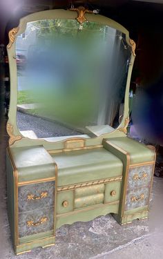 an old dresser with a large mirror on it's top and gold trimmings