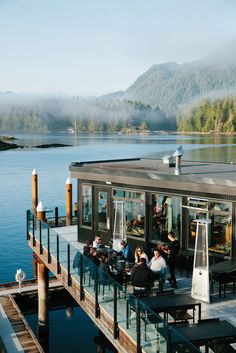 people are sitting at tables on the dock