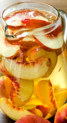 a pitcher filled with liquid and sliced apples