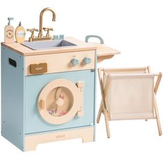 a wooden play kitchen with sink and laundry chair next to it on a white background